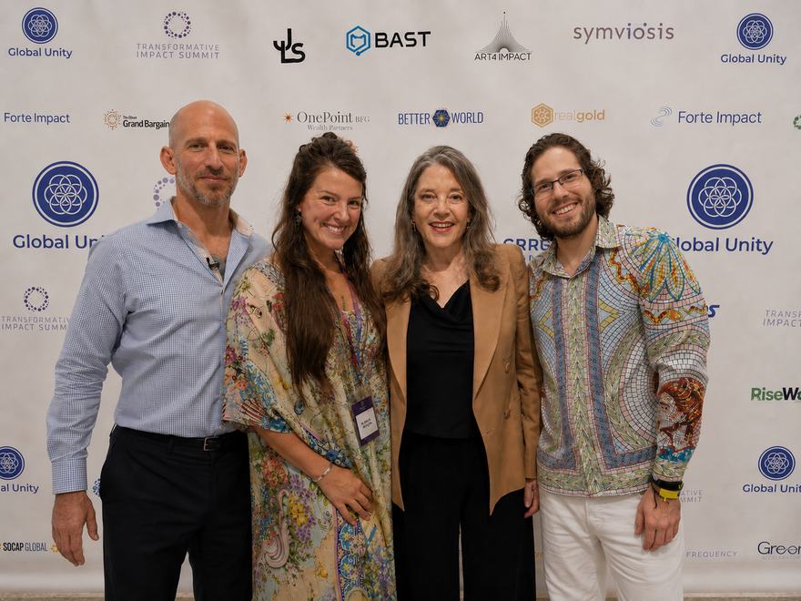 Elliott Bayev, Kayla Rose Bergen, Marianne Williamson and Vaughn Bergen standing together in front of the Global Unity and Transformative Impact Summit sponsor wall at the 2025 family office days in New York.