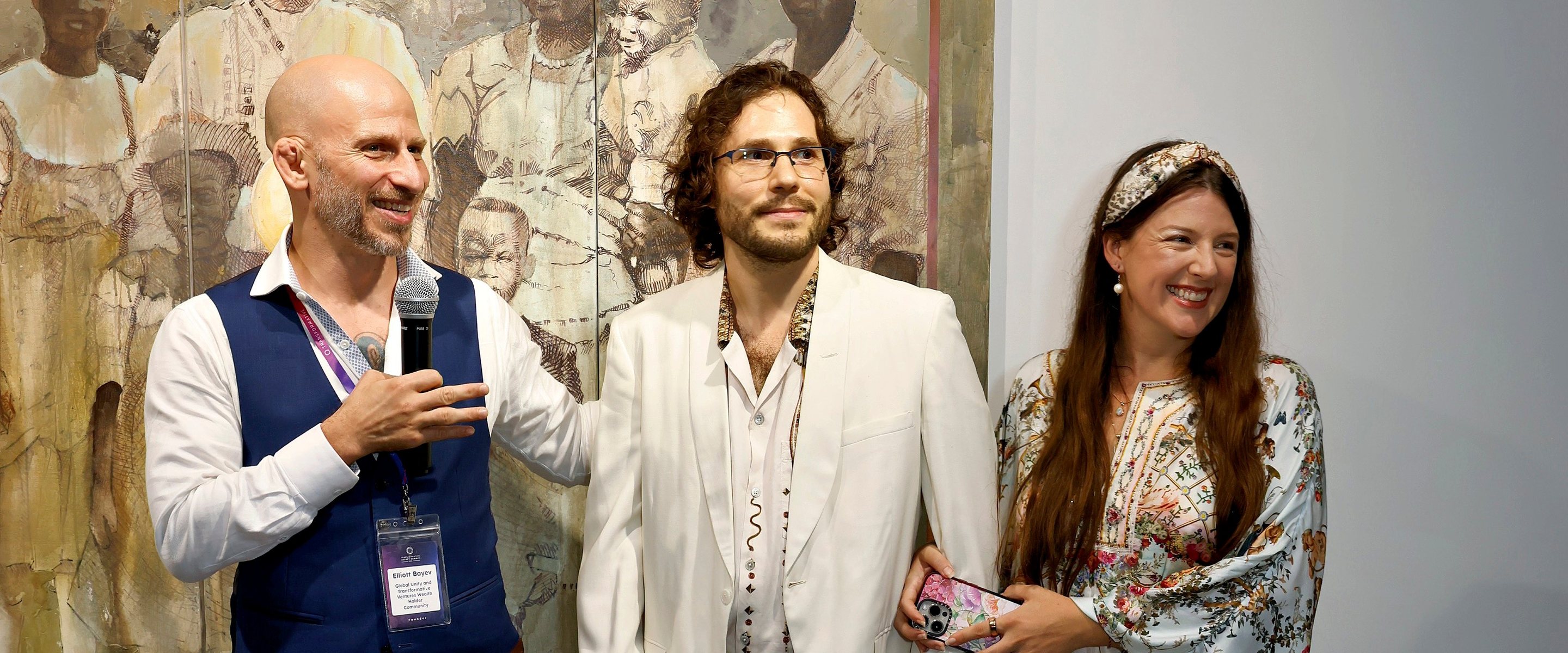 Three people standing and smiling in front of a large three-panel figurative painting at ACA Galleries during the 2025 Family Office Meta Gathering.