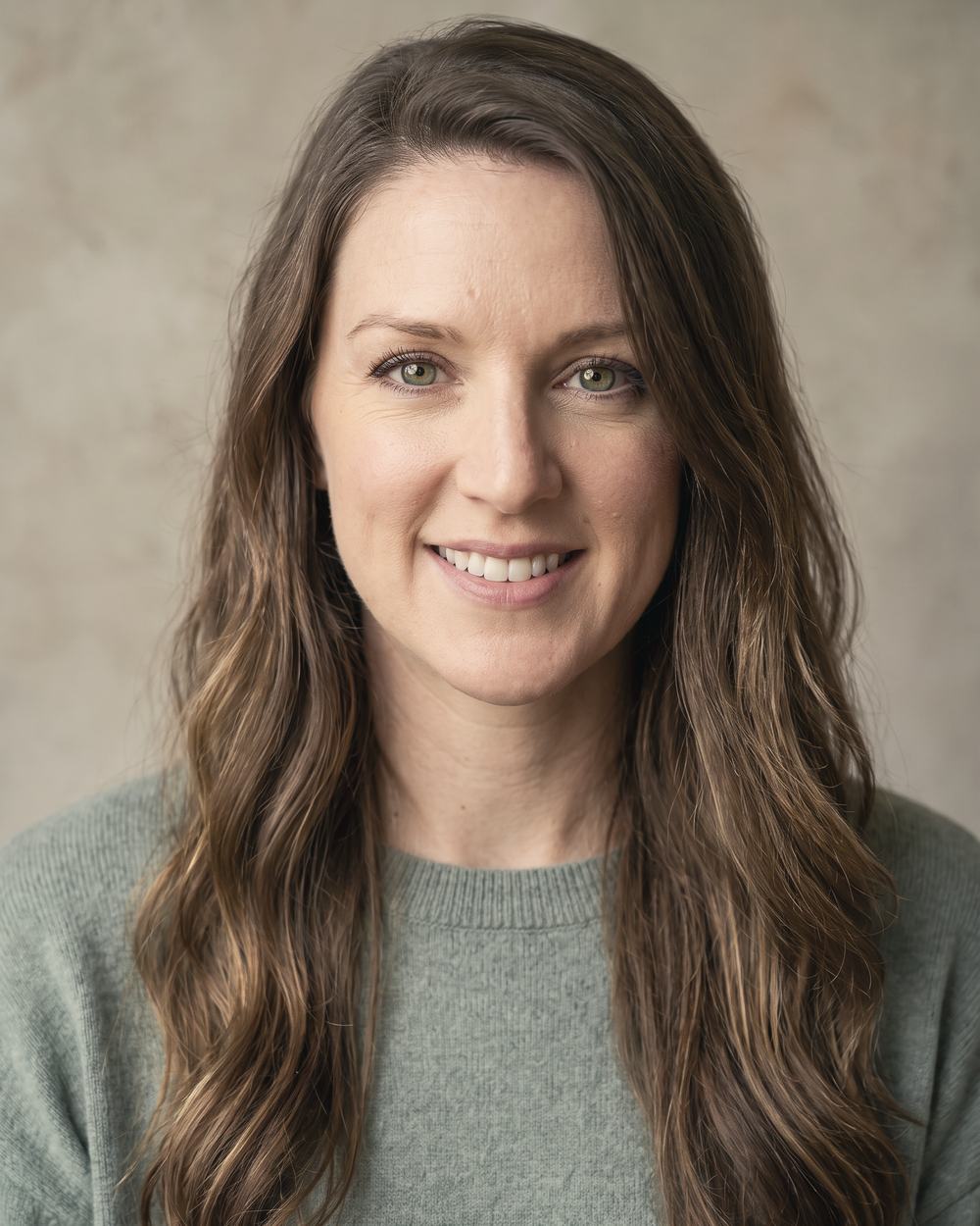 Kayla Rose Bergen, head and shoulders, against a soft grey ground.